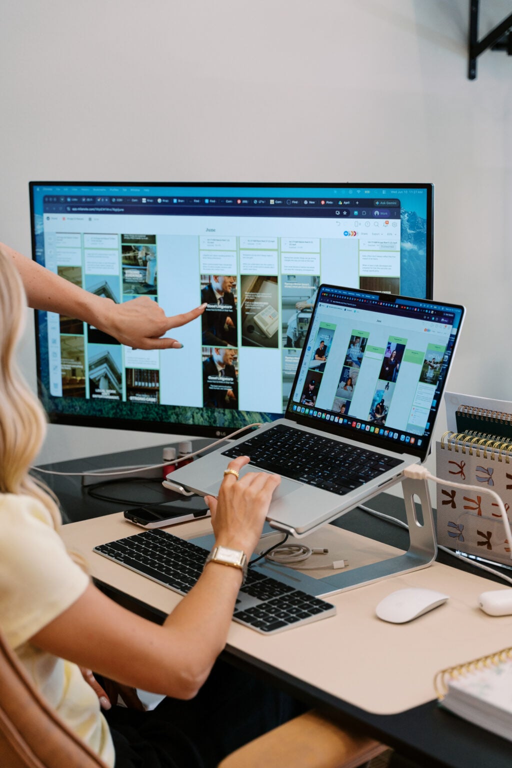 Social media manager pointing at a content calendar on a large monitor
